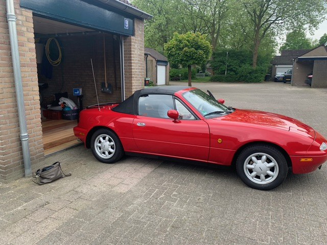 Rode Mazda MX-5 cabrio van opzij