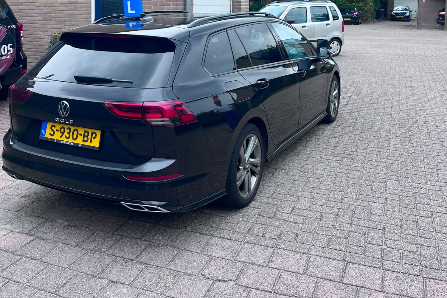Achterzijde van de zwarte Volkswagen Golf lesauto