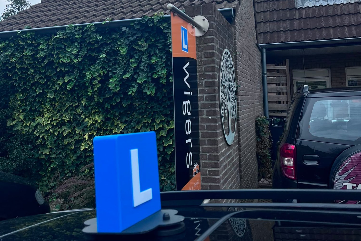 Lesauto met lesbord bij de locatie in Assen